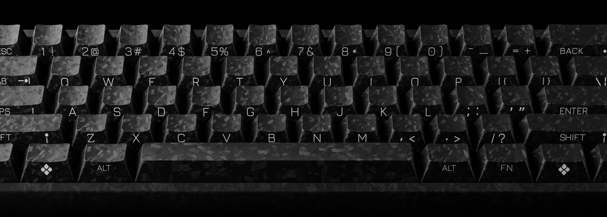 A close-up of a dark, textured mechanical keyboard with white lettering on the keys, shown against a black background.